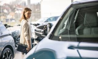 Woman browsing vehicles at a car dealership