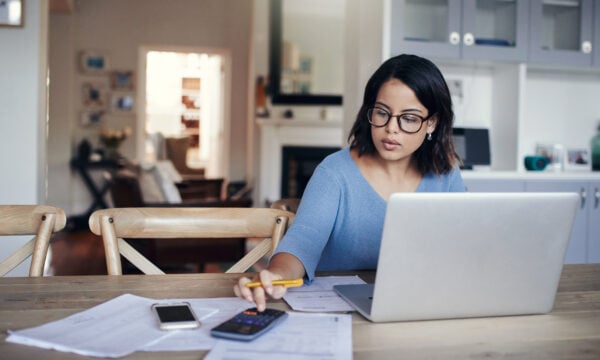 Person using a calculator and sitting at table