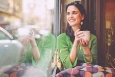A young woman smiling after checking her EQ Bank TFSA savings account balance.