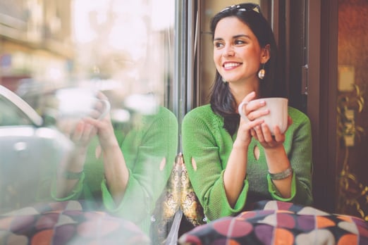 A young woman smiling after checking her EQ Bank TFSA savings account balance.