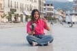 An influencer recording a travel vlog sitting at a tourist spot.