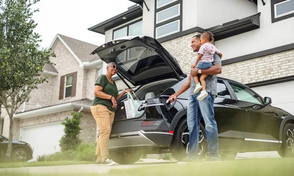 people unloading a car in front of their house