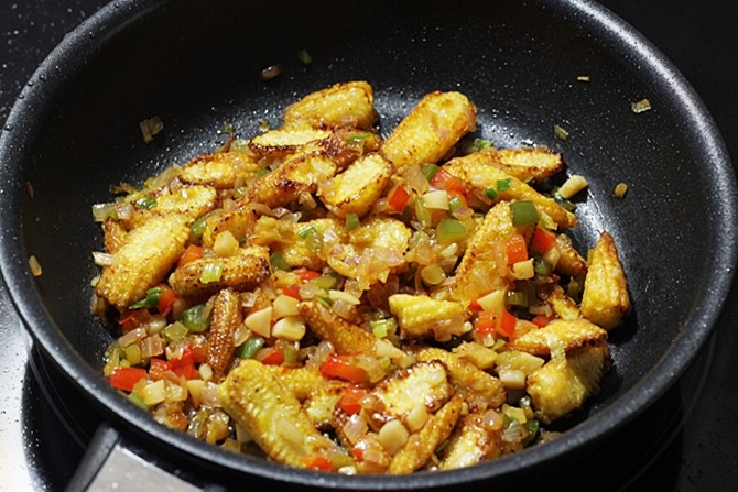 tossing baby corn in manchurian sauce