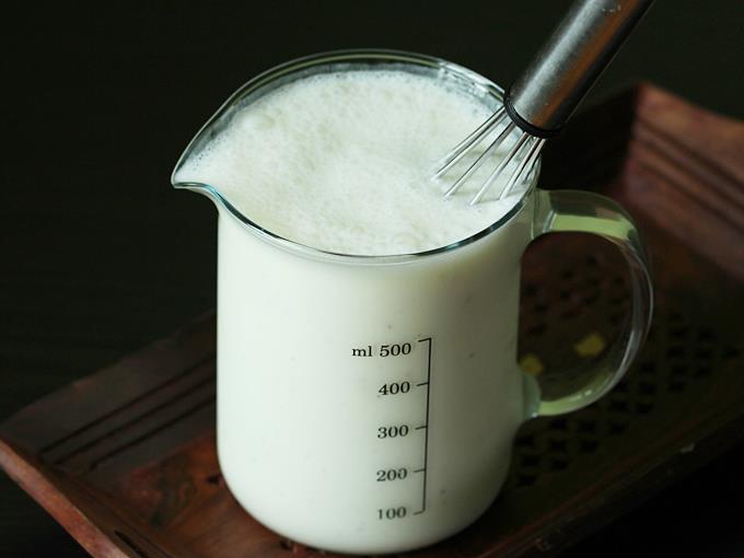pouring water to whisk curd