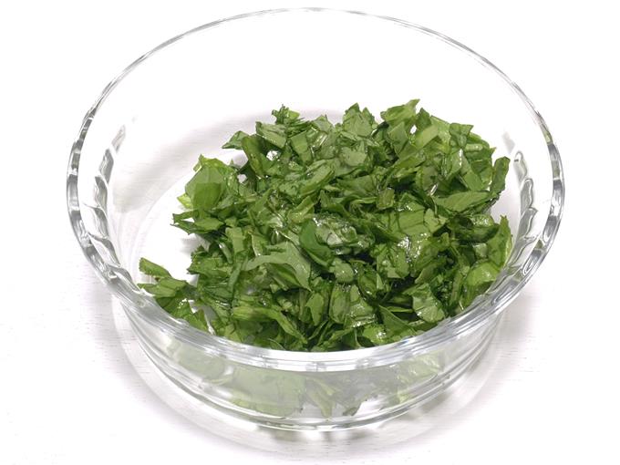 Adding chopped spinach to bowl