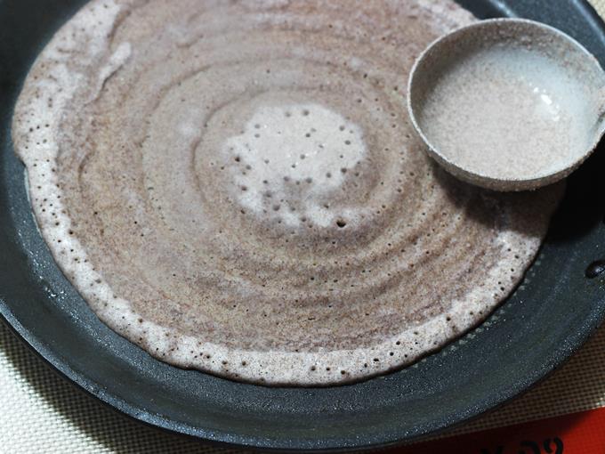 spreading batter on tawa