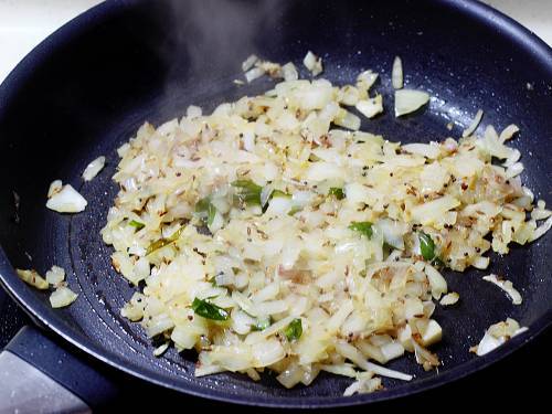 stir frying onions to make sweet potato stir fry.