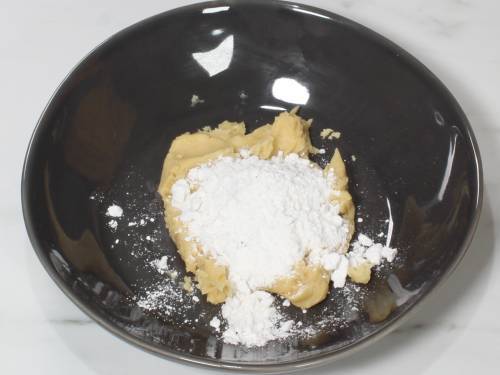 adding sugar and cardamom powder