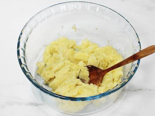 mashing potatoes in a bowl