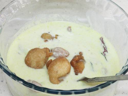 adding punugulu to tempered yogurt.