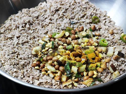 brown pan roasted flattened rice topped with tempering
