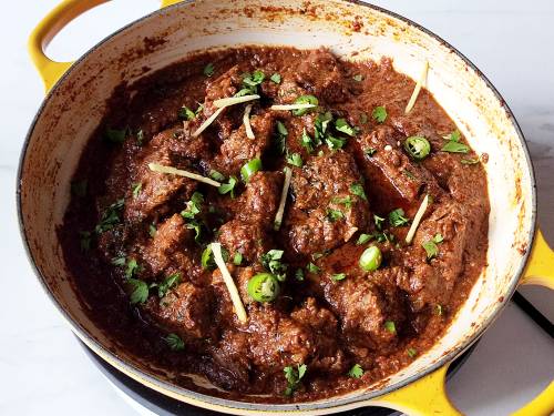 garnishing lamb karahi in a kadai