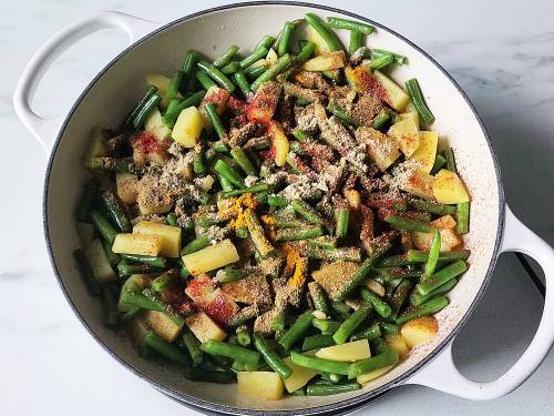 add spices to the sauteed green beans and potatoes