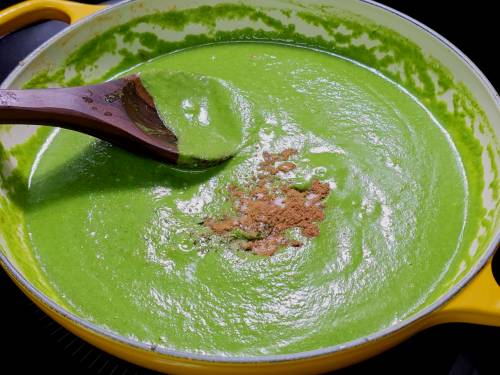 adding spices to palak curry