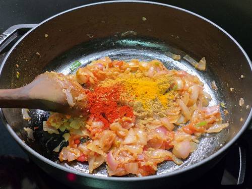 adding in the spices to the curry